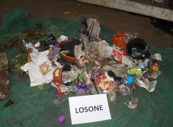 I rifiuti illegali, plastica, carta e altro, gettato impropriamente nel bidone del verde.