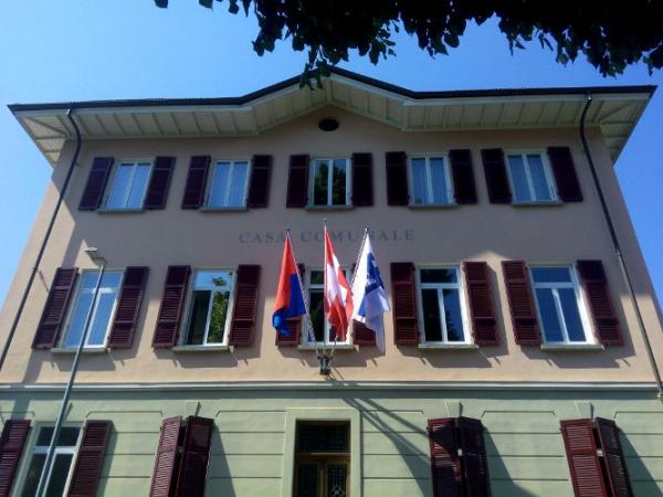 Le bandiere di Svizzera, Ticino e Losone sventolano sulla facciata di Palazzo comunale a Losone